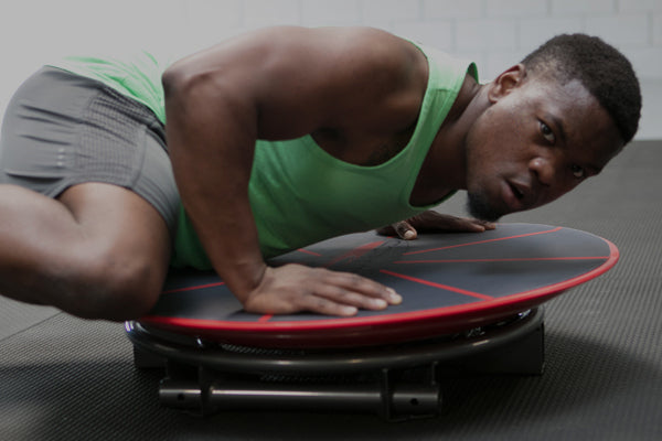 Athletic man doing push-up exercise on the red Core-Tex Reactive trainer